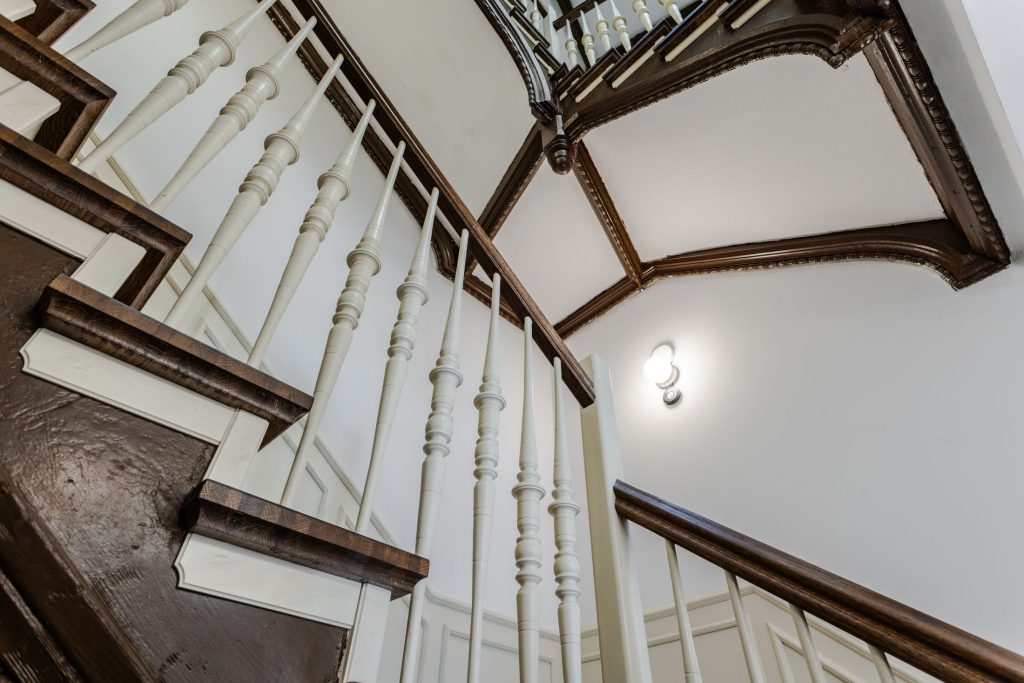 Odnowiona klatka schodowa z rzeźbioną balustradą – widok w górę